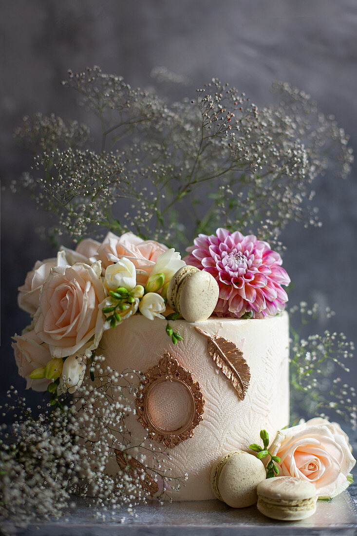 Festive white wedding cake decorated with flowers and gypsophila