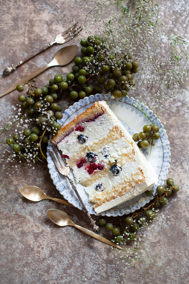 A piece of cream cake with berries on a plate