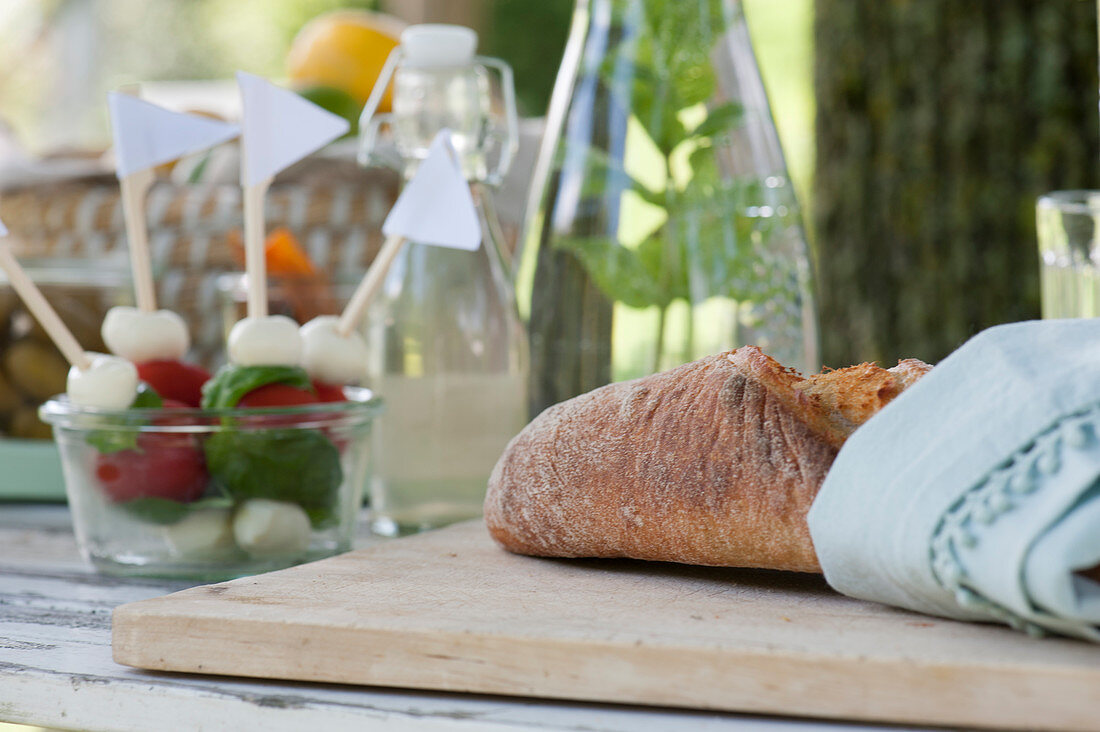 Fresh chiabatta on wooden board, mozzarella tomato skewers