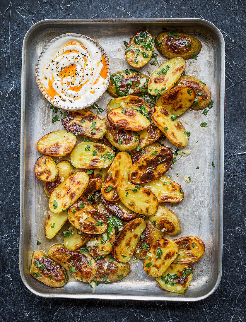 Roasted potatoes on baking tray with parsley and garlic