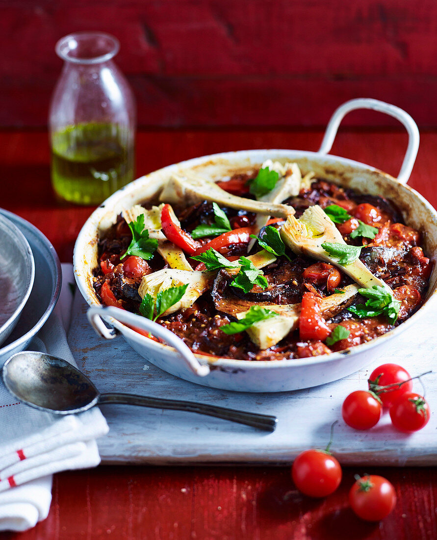 Vegetable black rice 'paella' with tomatoes and artichokes