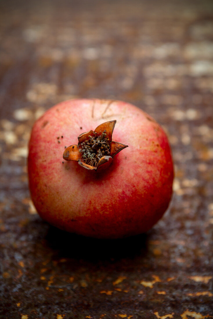 Ein Granatapfel auf rostigem Untergrund