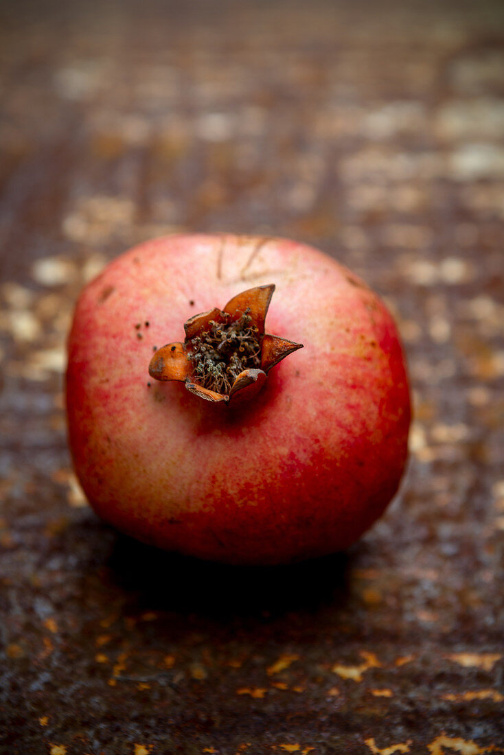 Pomegranate on a rusted surface