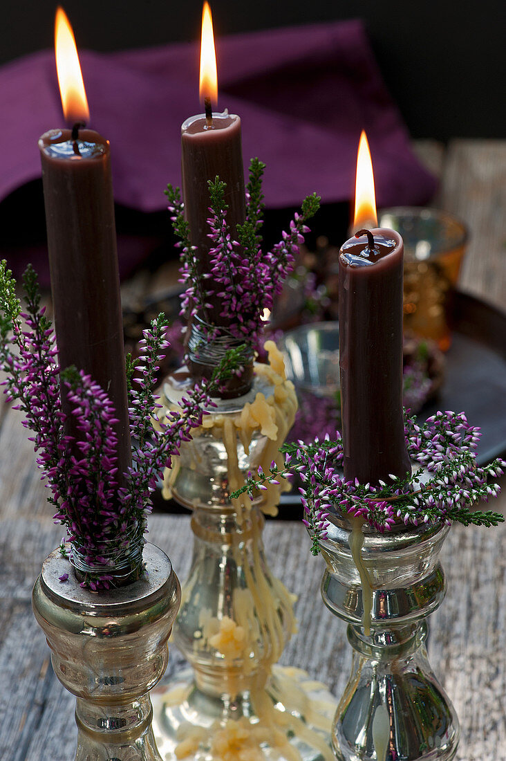 Candlestick with budding heather and burning candles