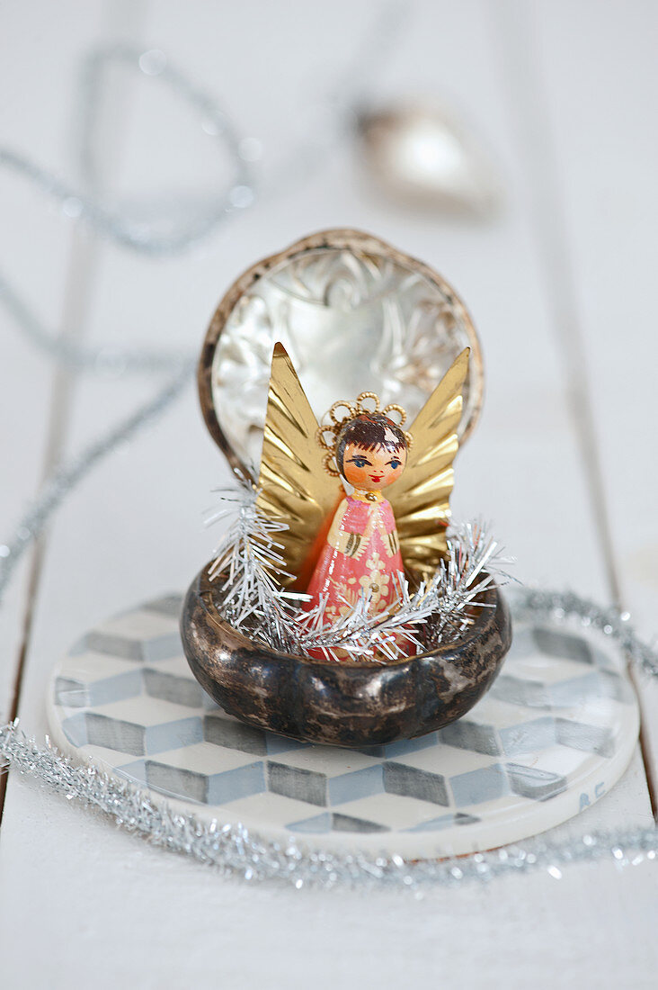Little angel with silver branches in a powder box