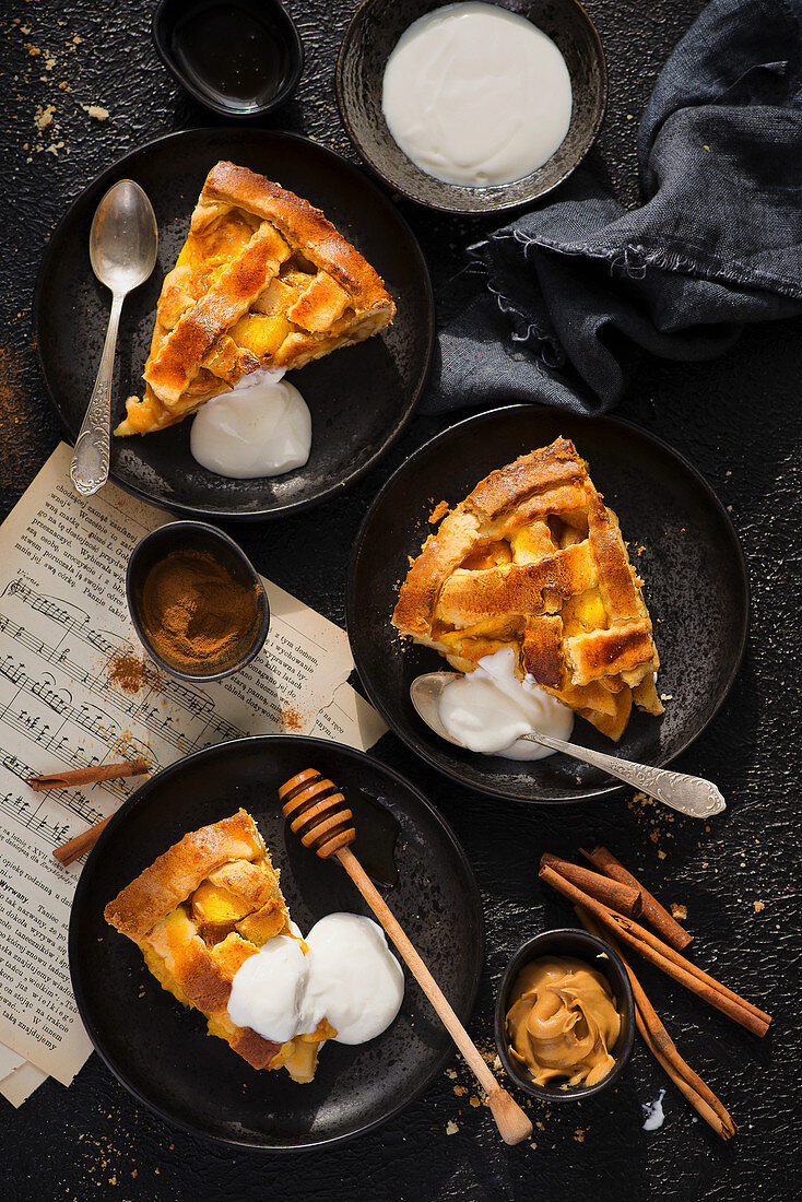 Portions of traditional apple pie with cinnamon and yoghurt