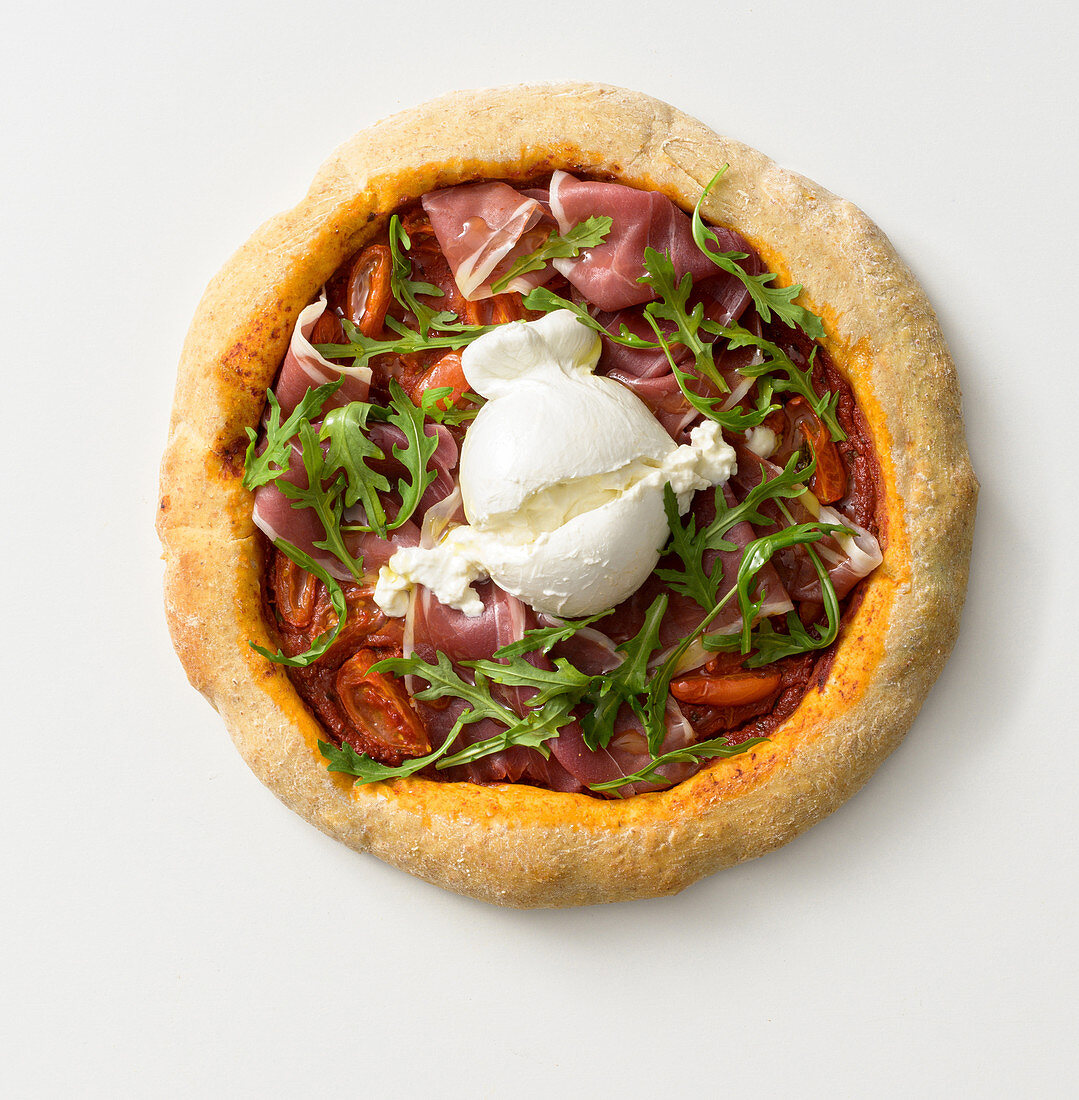 Wholemeal pizza with cured ham, burrata and rocket