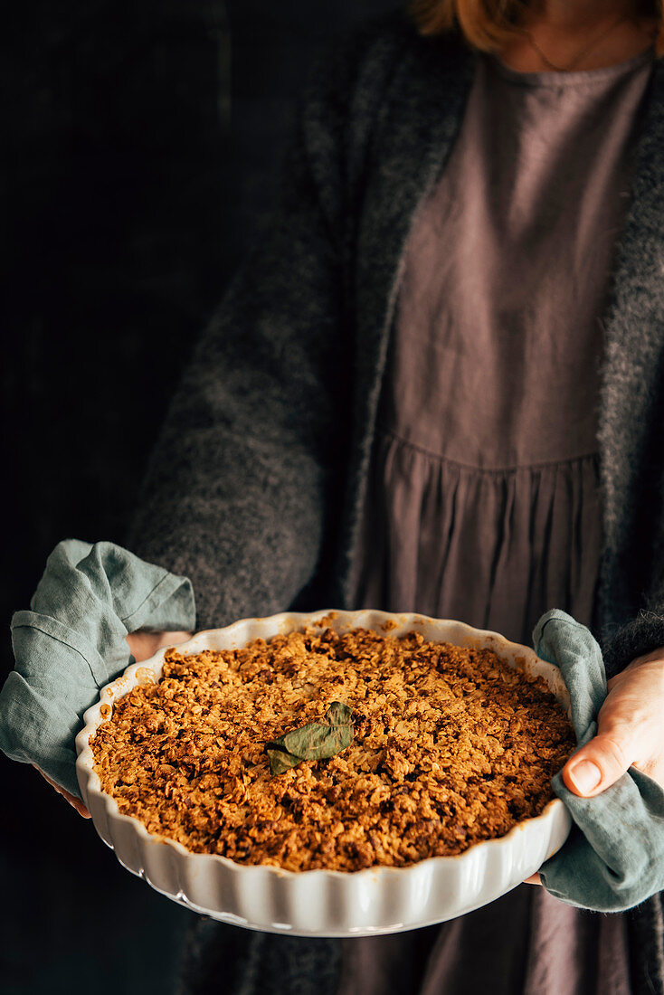 Woman serving apple oat crumble