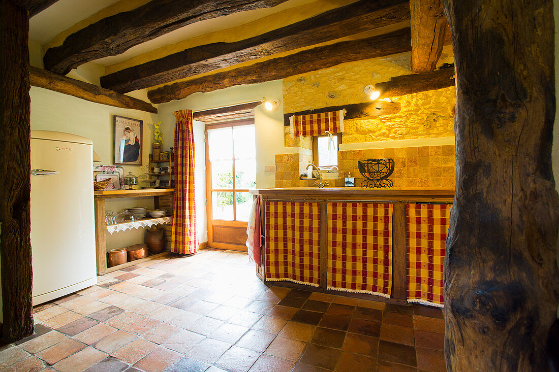 Rustic kitchen with rustic wood-beamed ceiling