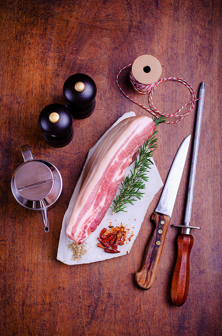 Piece of pork belly with a sprig of rosemary