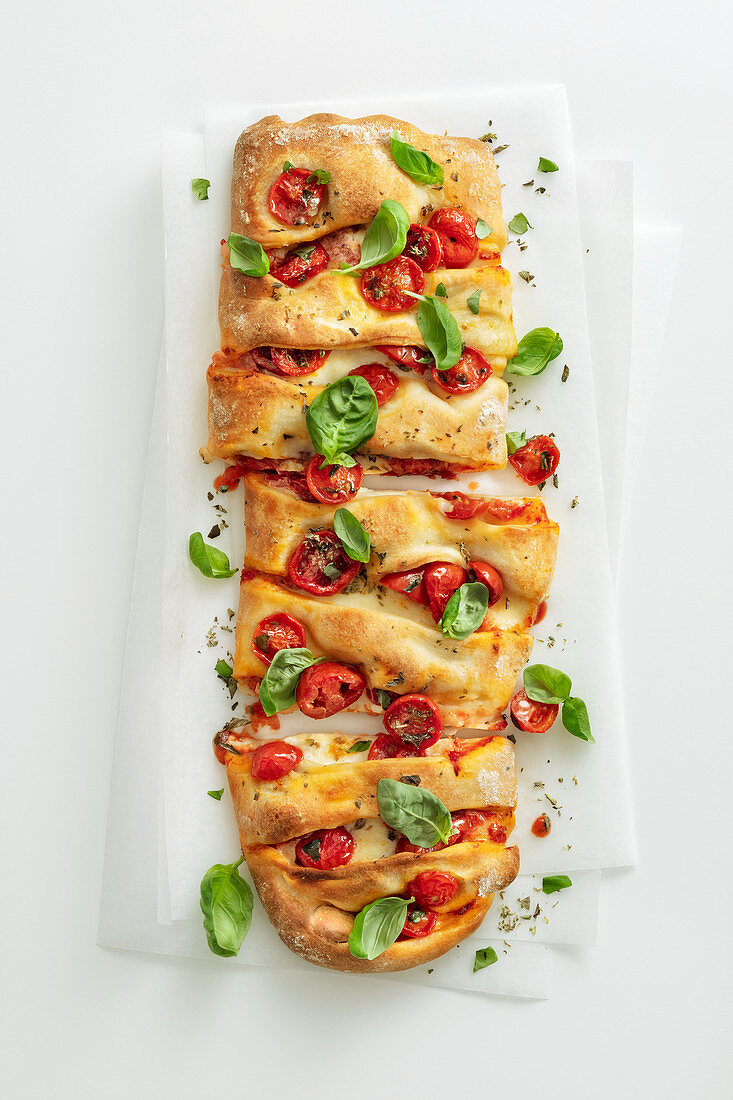 Rustic elongated pizza with cherry tomatoes and mozzarella