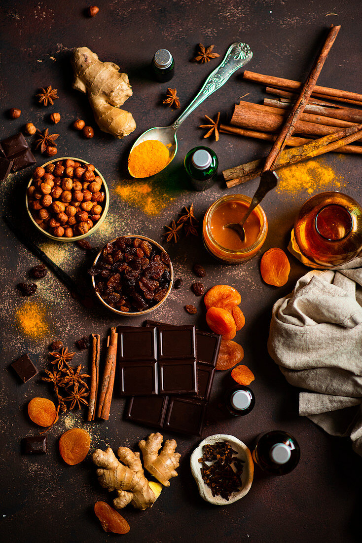 Winter spices ginger, cinnamon, star anise, turmeric, dryed apricots, raisins, hazelnuts, chocolate and caramel