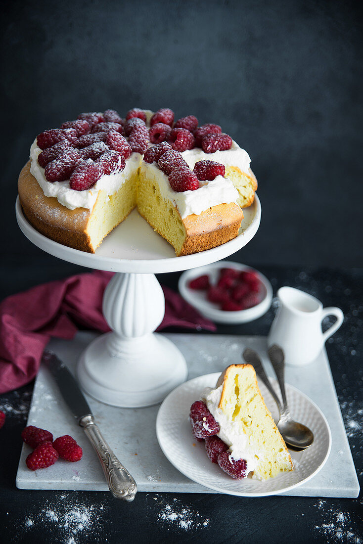 Sponge cake with whipped cream, raspberries and powdered sugar