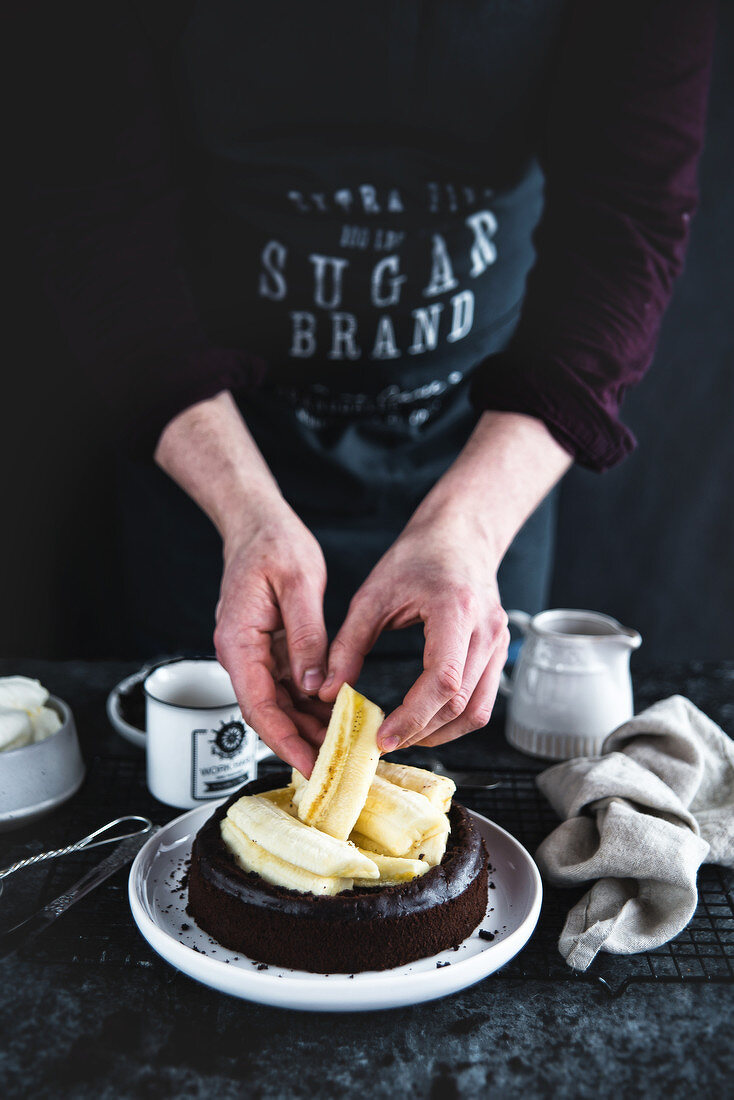 Man preparing of chocolate cake with bananas