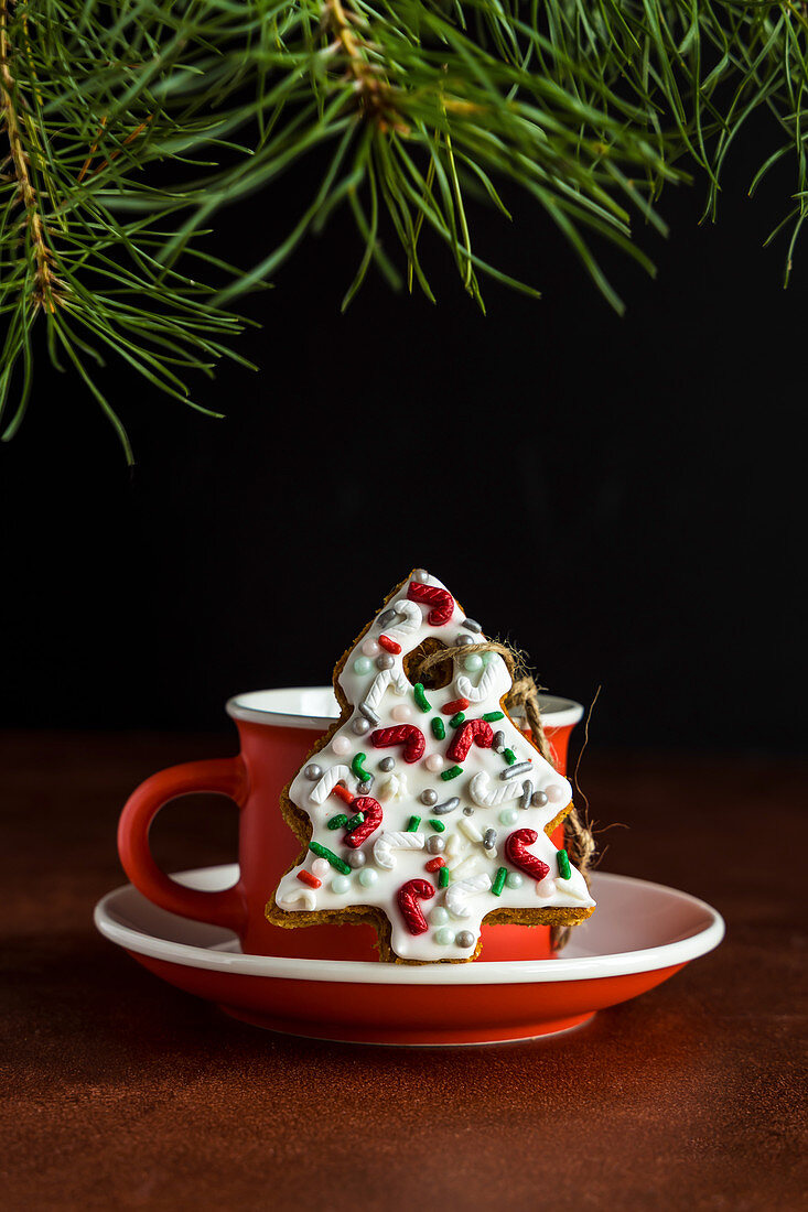 Weihnachtsbaum-Lebkuchenkeks mit Zuckerstreuseln und Zuckerguss