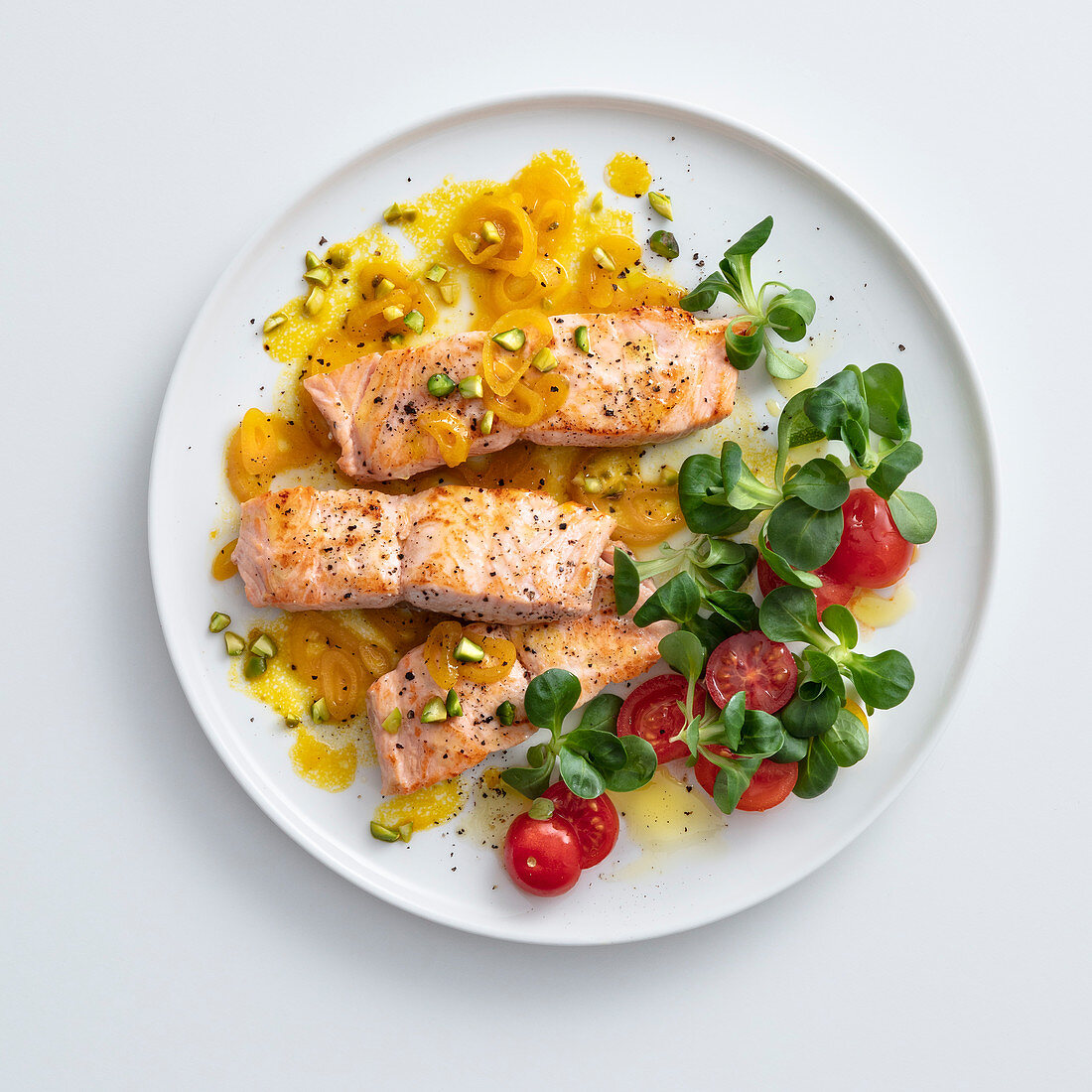 Salmon fillet with yellow cherry tomatoes and pistachio nuts