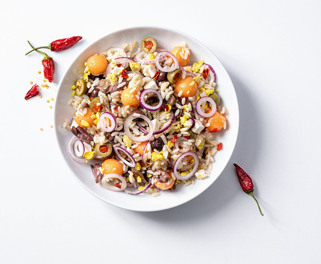 Rice salad with olives, eggs, anchovies, sheep's cheese and melon