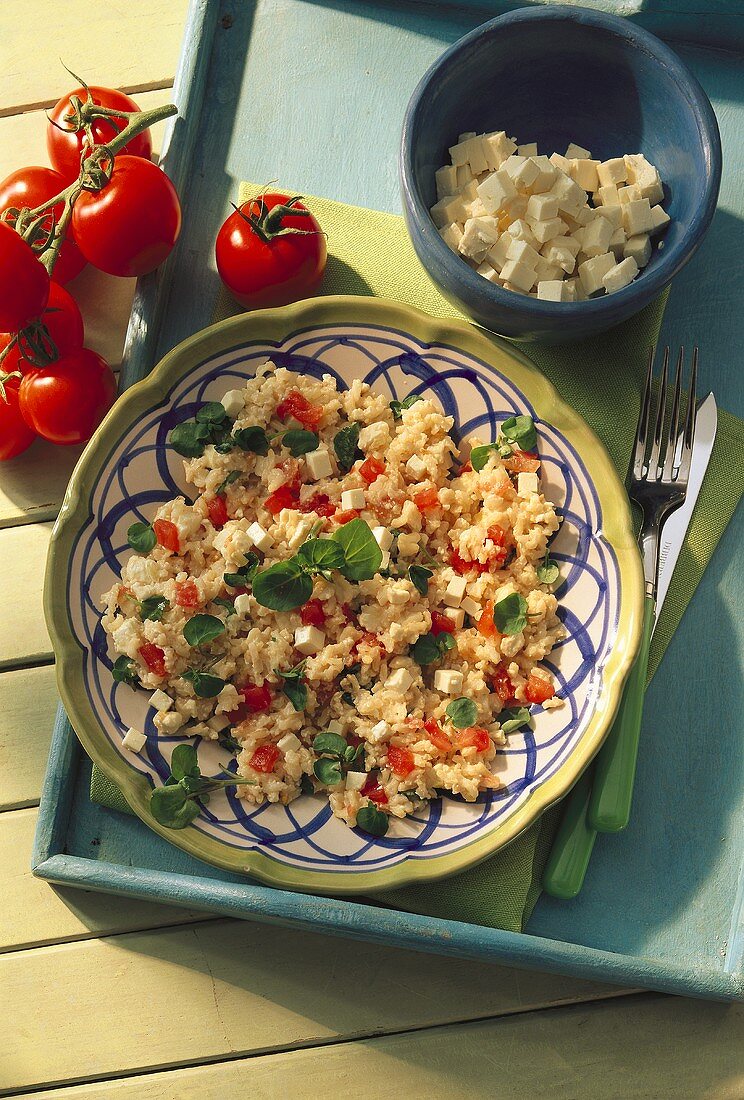 Rice salad with tomatoes, sheep's cheese and watercress