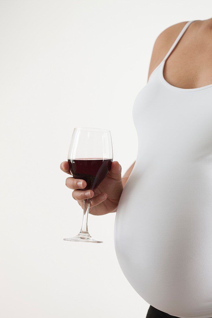 Pregnant woman holding a glass of red wine
