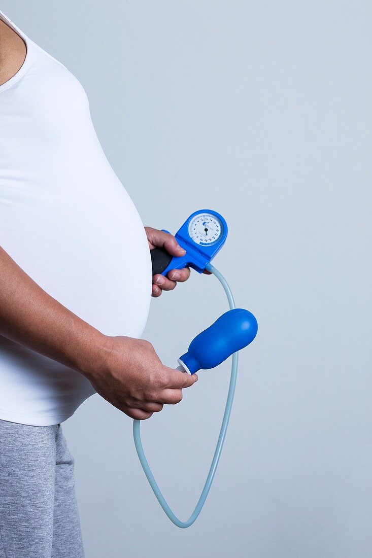 Pregnant woman holding pelvic floor trainer