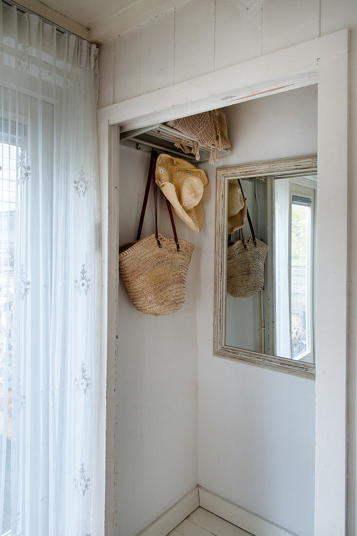 Coat rack and mirror on wall in niche