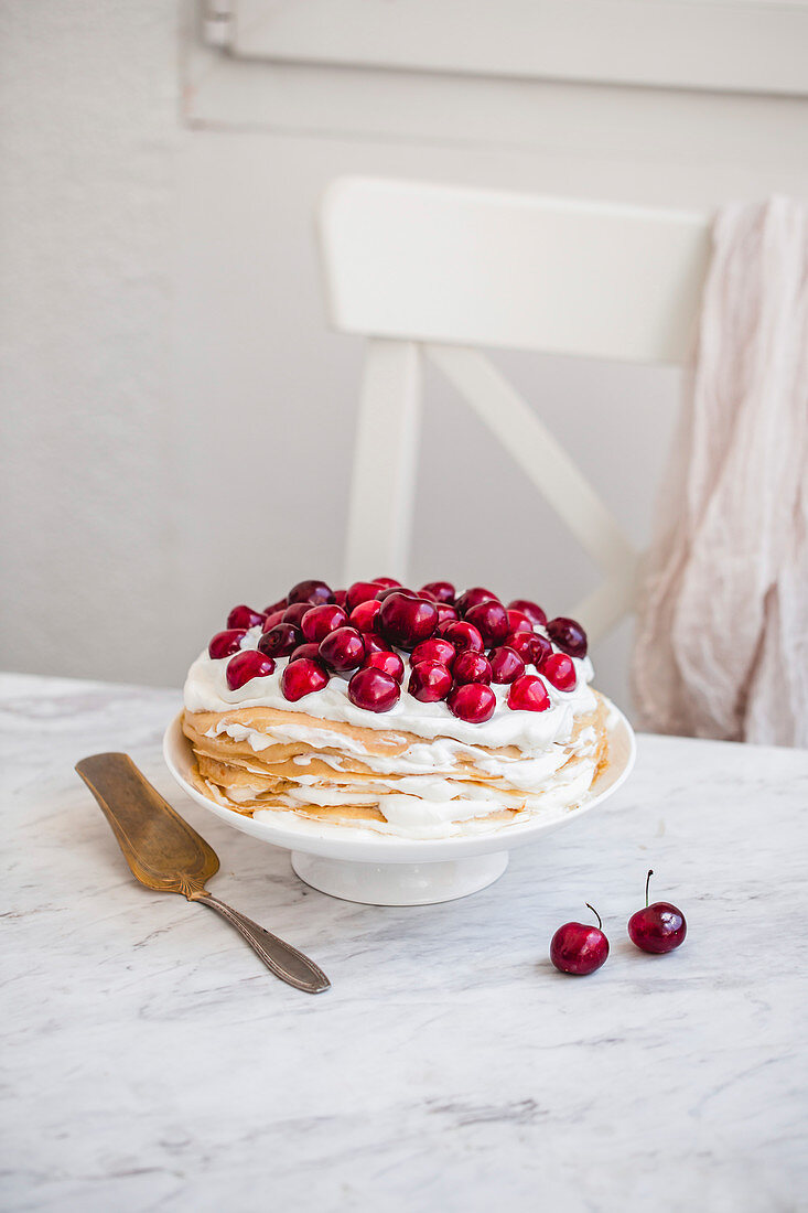 Crepes stack with whipped cream and cherries