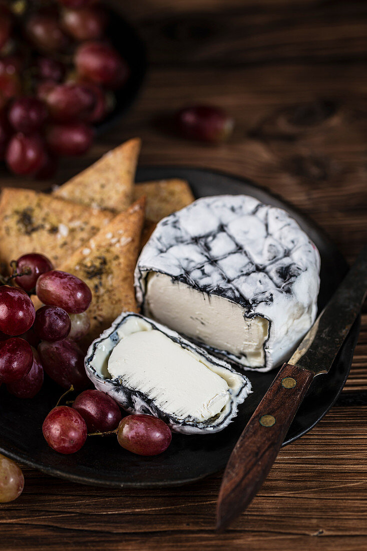 Ashed Brie served with crackers and brie on a wooden background