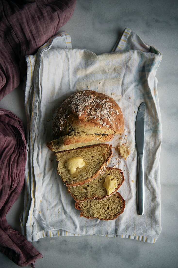 Soda bread without yeast half sliced ona cotton white tea towel