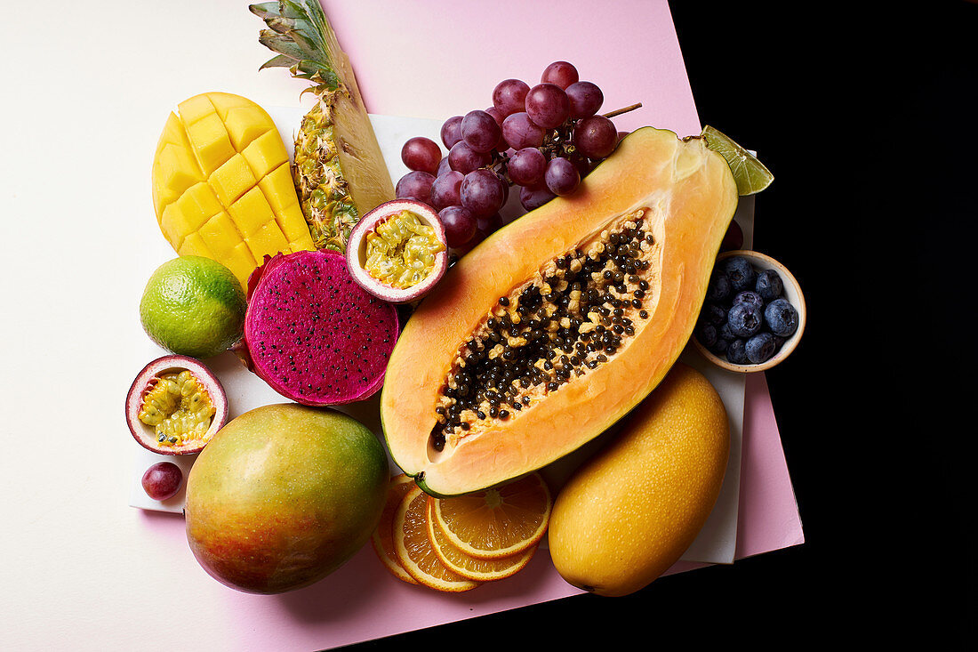 Tropical fruits flat lay with mango, papaya, pitahaya, passion fruit, grapes, lime and pineapple