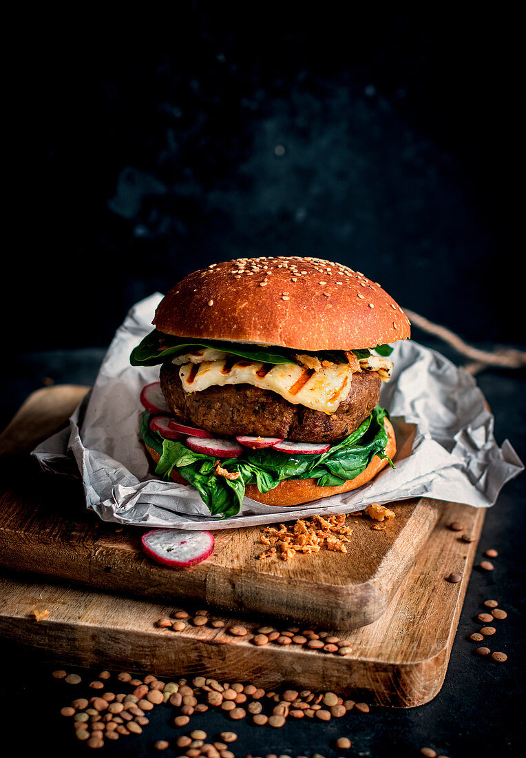 Lentils vegan hamburgers placed on wooden board on dark background