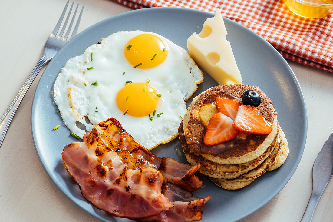 Delicious fried eggs with bacon and cheese for breakfast