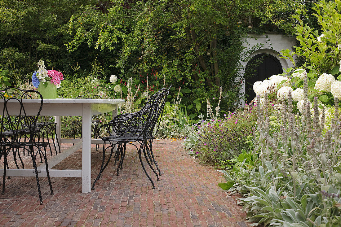 Table and wrought iron chairs on brick terrace