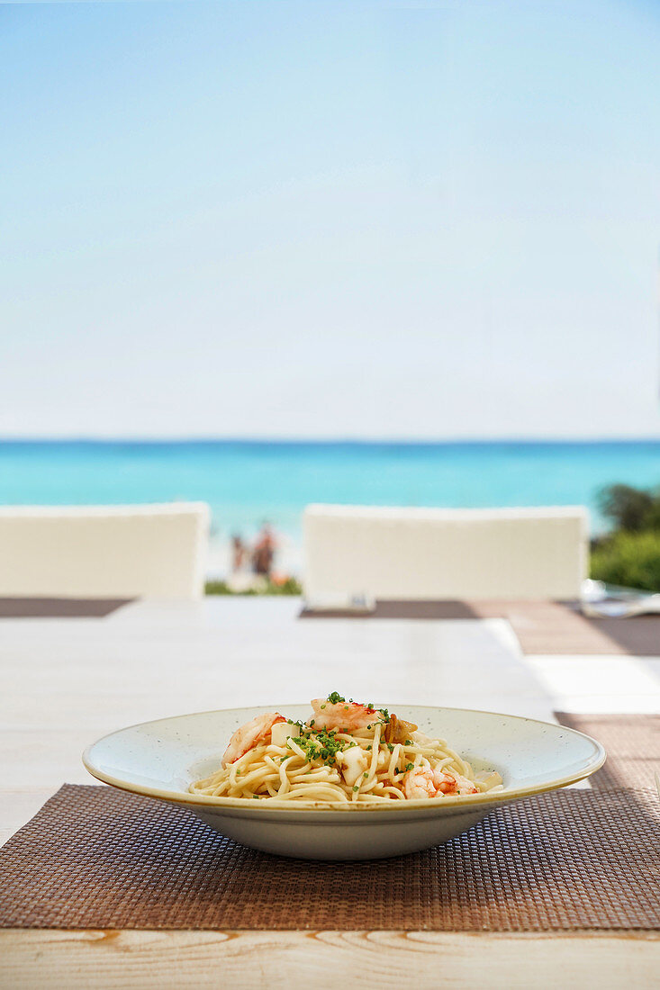 Spaghetti mit Garnelen auf Tisch mit Meerblick