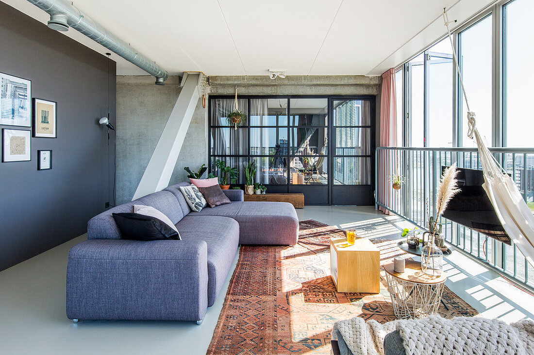 Grey sofa in living room with folding glass wall