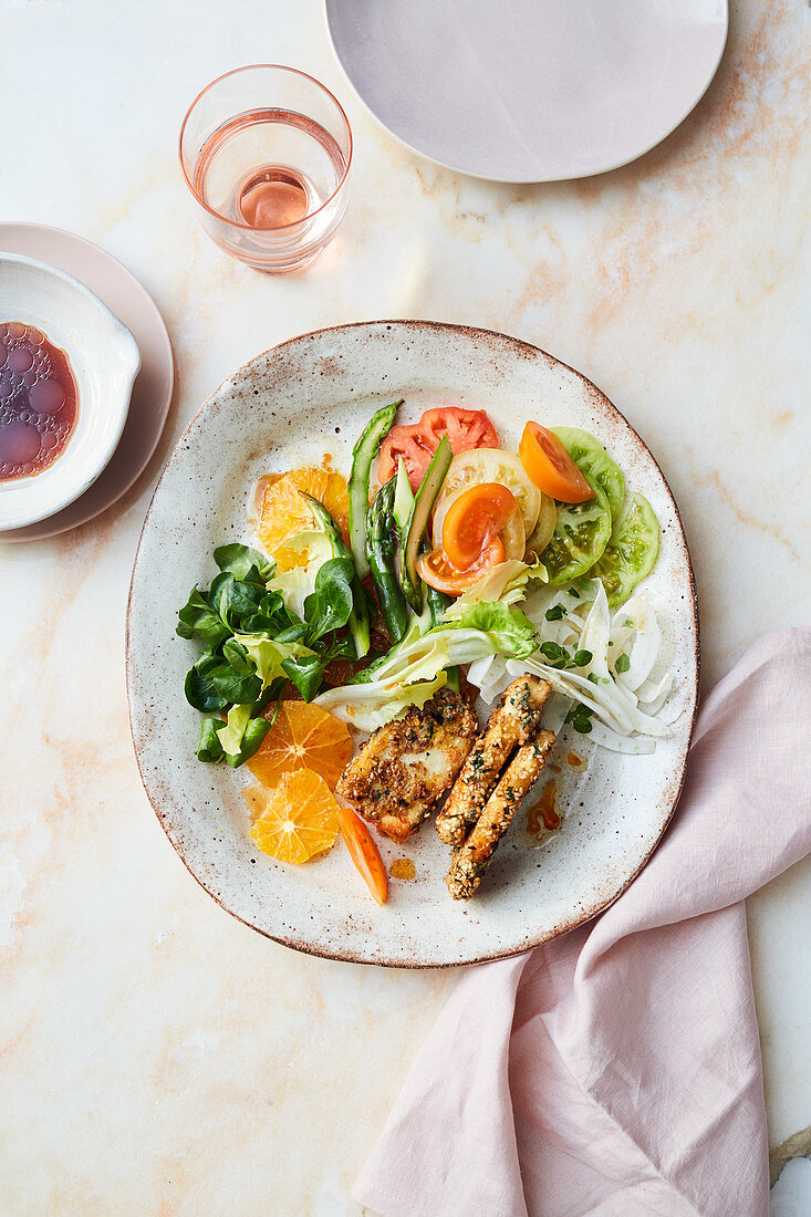 Lamb's lettuce salad with green asparagus, tomatoes, oranges and halloumi