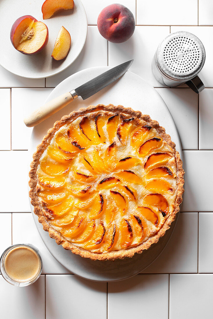 Peach tart on a plate over a white background