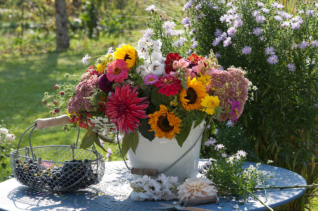 Late summer bouquet with sunflowers, zinnias, dahlias, sedum plants, snapdragons, delphiniums, ornamental apples and autumn asters