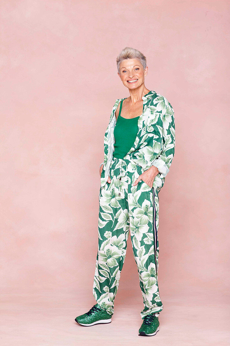 A grey-haired woman wearing subtle a leaf-print trouser suit