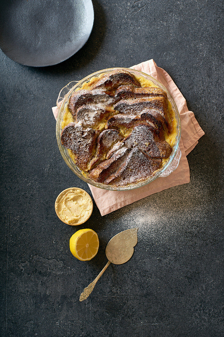 Bread Pudding mit Custard, serviert mit Orangenschalenbutter und Puderzucker