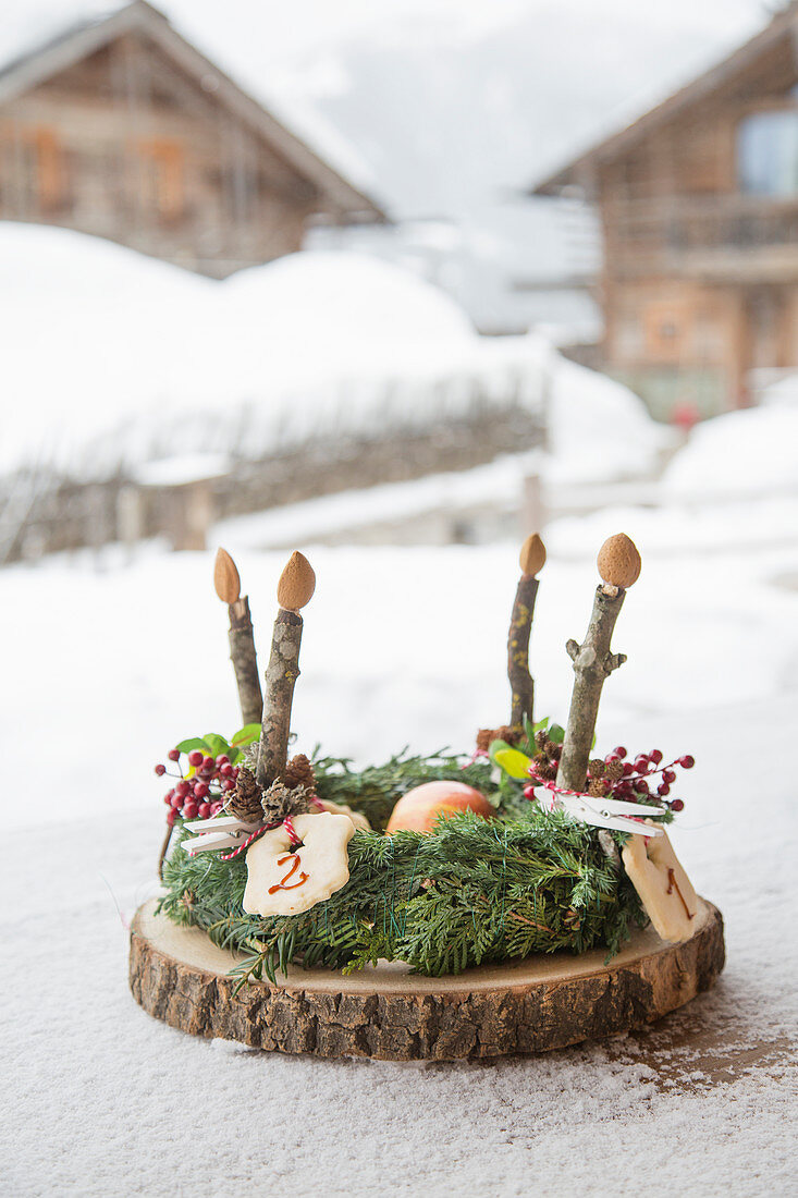 Adventskranz mit nummerierten Plätzchen und Kerzen aus Holz