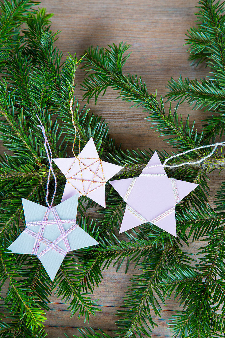 Selbstgemachter Christbaumanhänger aus mit Garn umwickeltem Papier