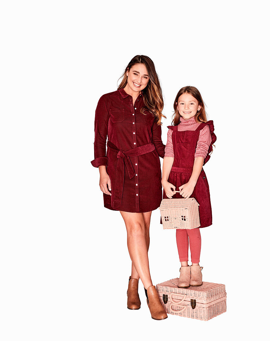 A mother and daughter wearing similar outfits (red dresses)