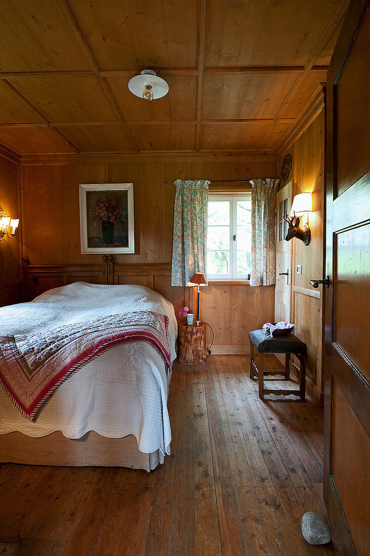 Country-house-style bedroom with panelled walls and coffered ceiling