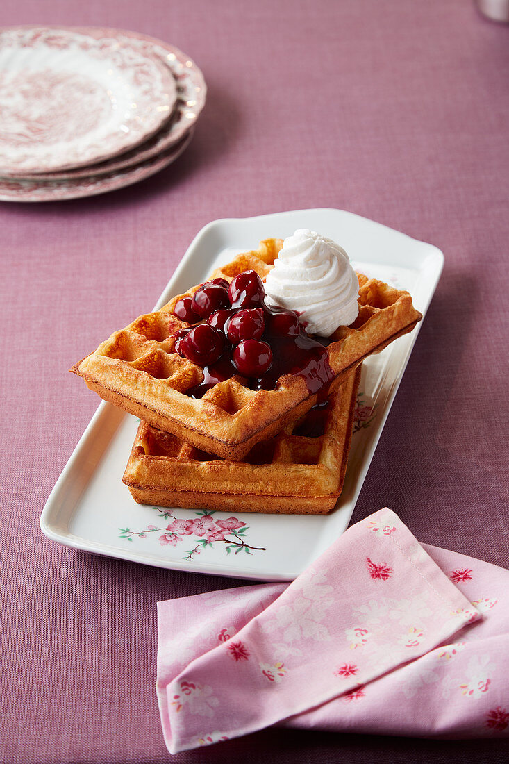 Waffles with sour cherries and whipped cream