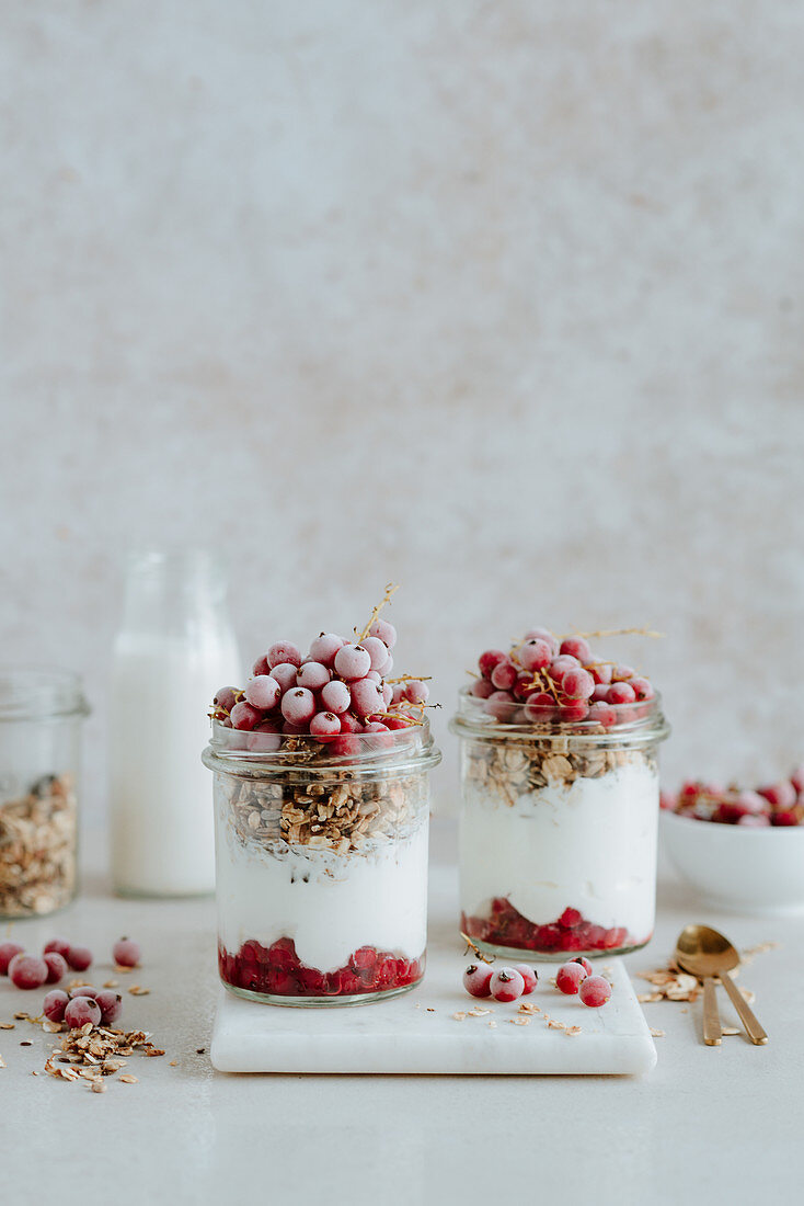 Müsli in einem Glas mit Joghurt und roten Johannisbeeren