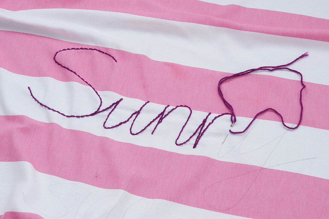 Embroidering pink-and-white striped cloth using backstitch