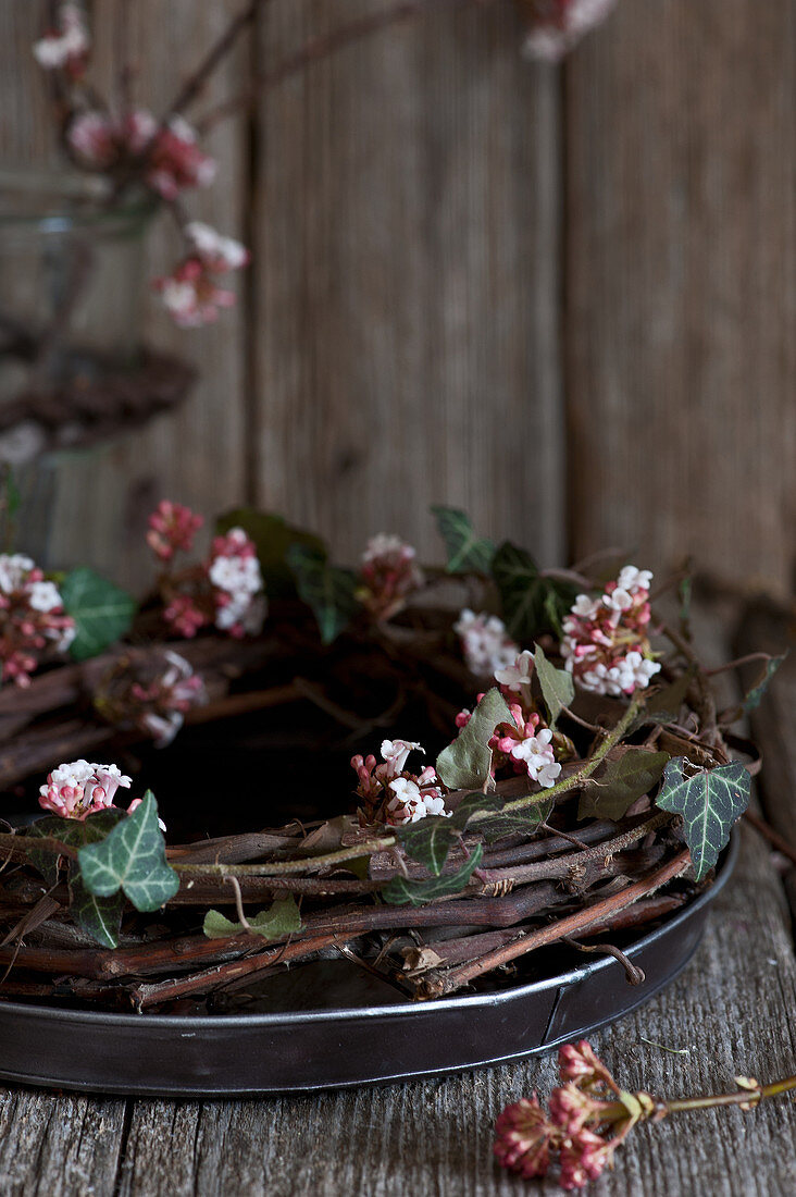 Wreath of Bodnant viburnum twigs and ivy tendrils on tray