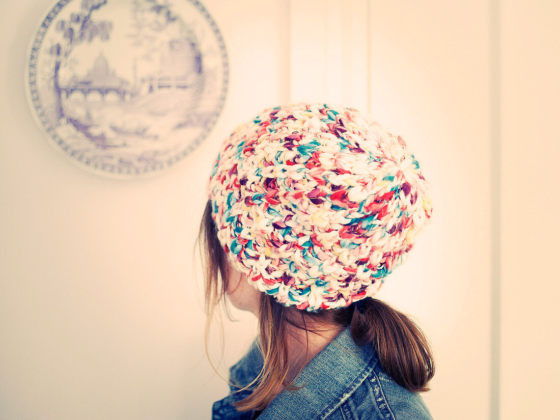 A woman wearing a colourful knitted hat