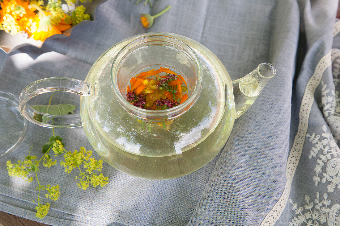 Freshly brewed flower tea in a glass jug