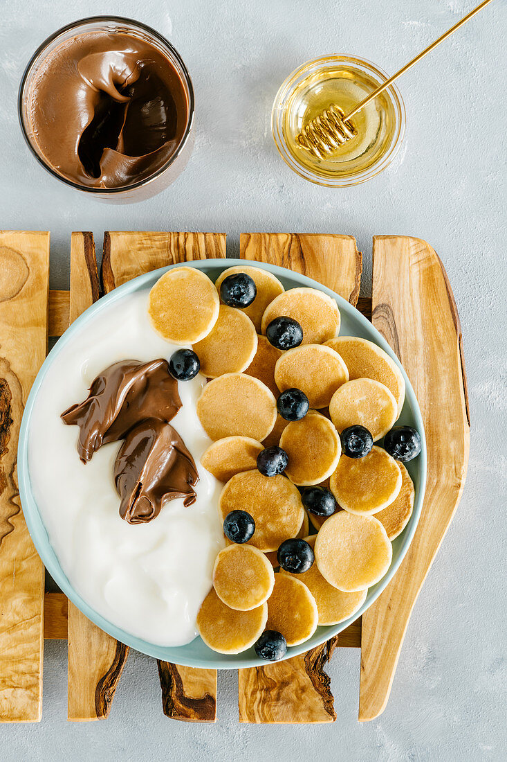 Mini pancakes with natural yoghurt, blueberry and chocolat cream